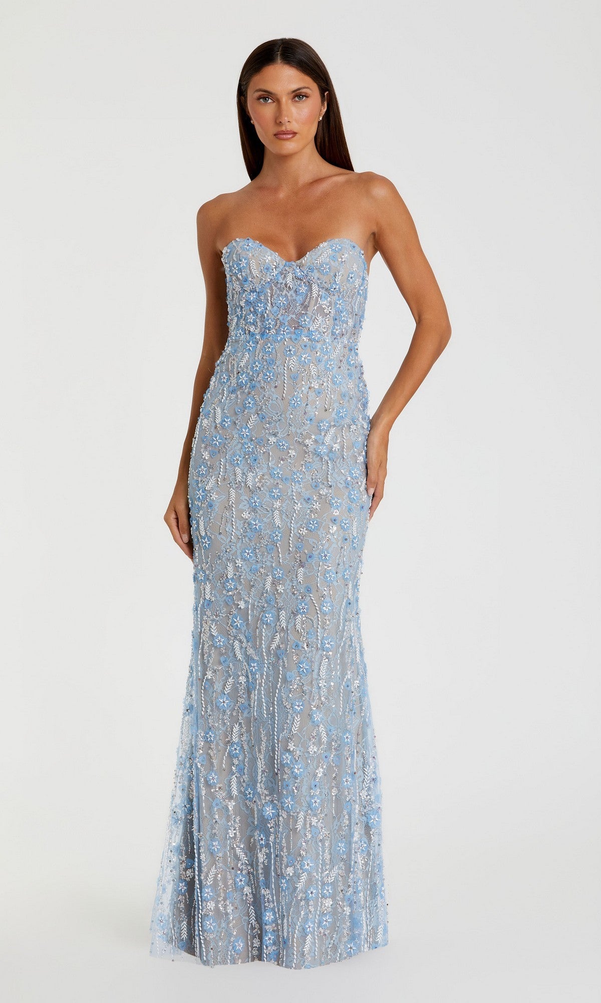 A woman wearing the Mac Duggal 68893 Long Formal Dress in blue, a strapless floor-length gown with a fitted silhouette, showcases intricate lace adorned with blue floral embroidery and delicate beadwork on a sheer overlay, set against a plain background.